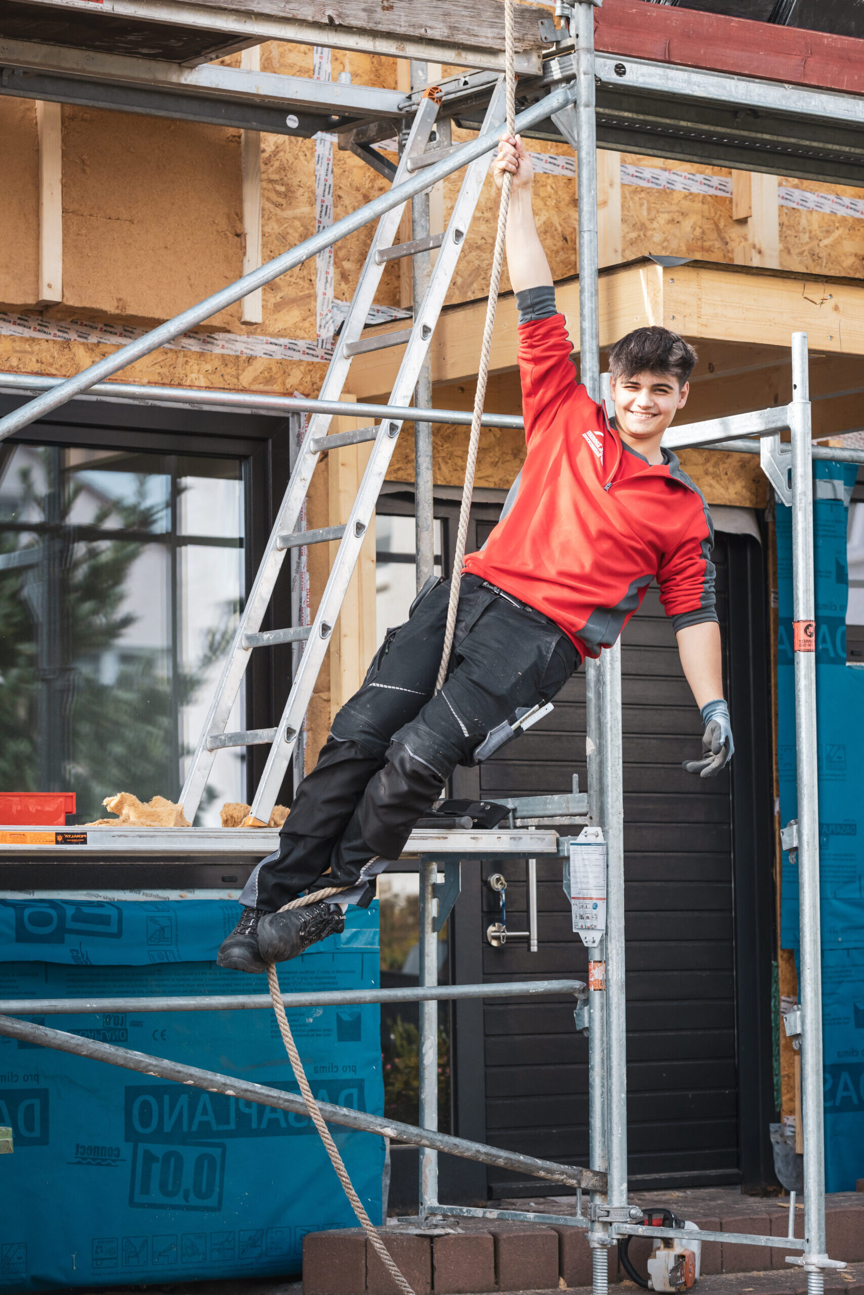 Dachdecker bei der Arbeit lachend am Gerüst