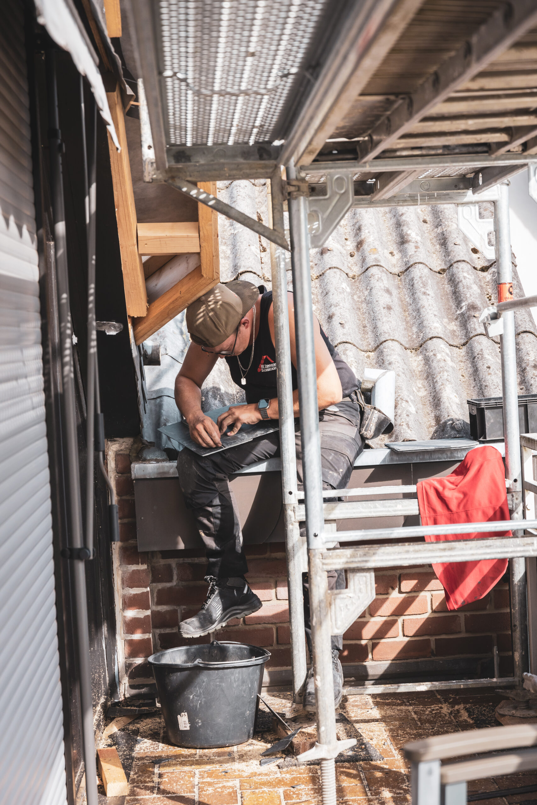 Dachdecker bei der Arbeit sitzend auf dem Dach